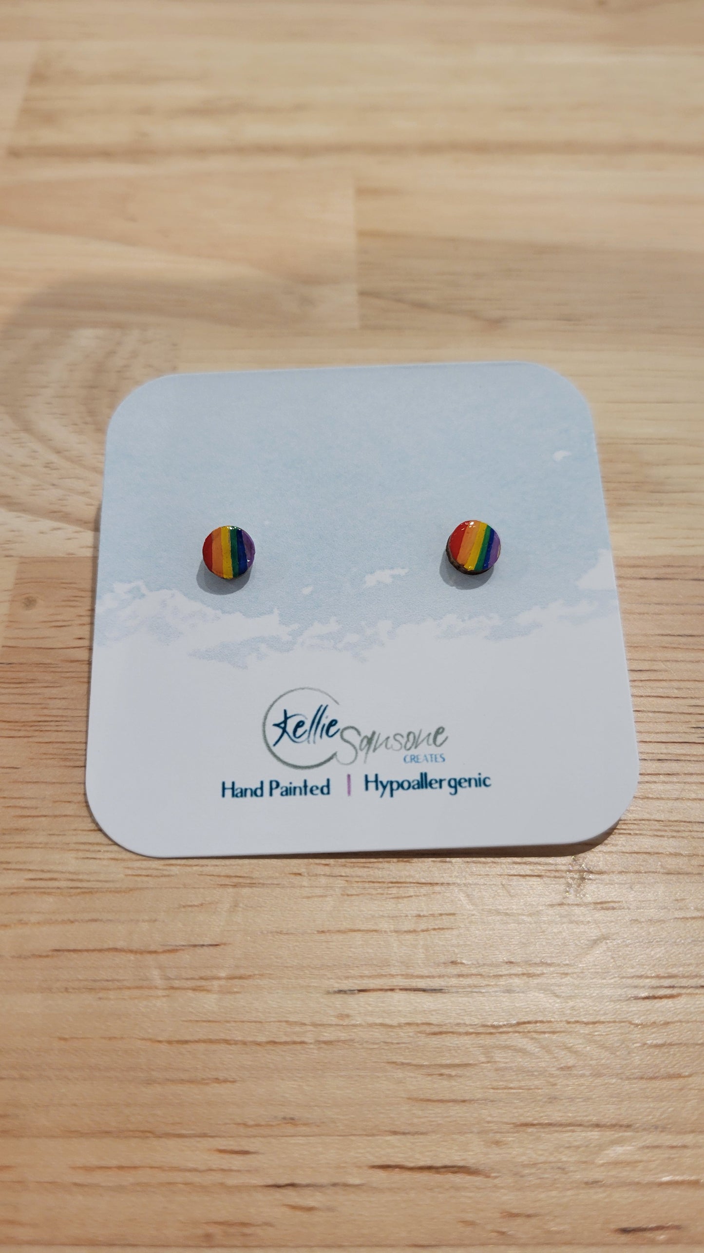 Circular earrings with pride rainbow flag design. Acrylic hand painted earrings from Kellie Sansone Creates