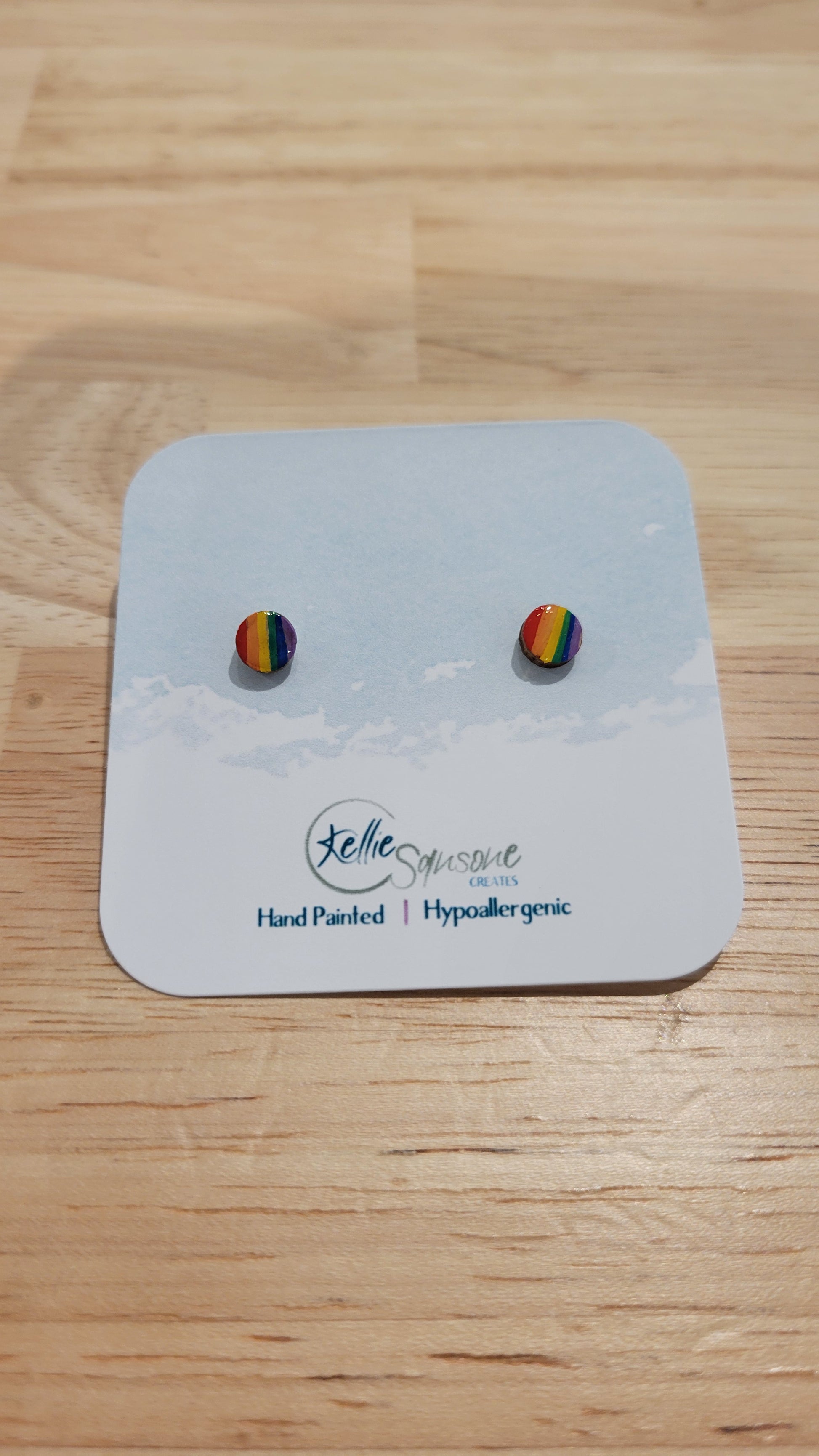 Circular earrings with pride rainbow flag design. Acrylic hand painted earrings from Kellie Sansone Creates